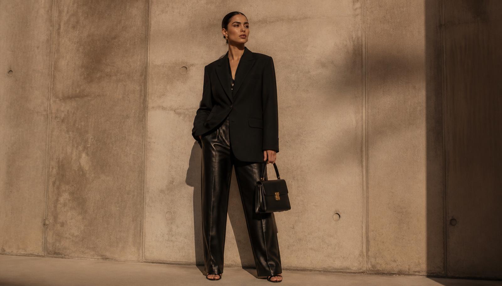 Femme portant un blazer oversize noir et un pantalon en cuir, collection nouvelle saison REEMAS